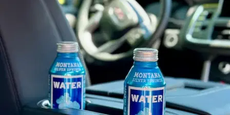 Interior of a luxury SUV with Montana Silver Springs water bottles in the cup holders.