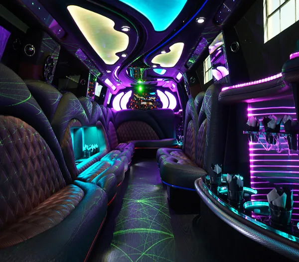 Interior view of a luxury party bus featuring plush seating, ambient LED lighting, and a champagne bucket.